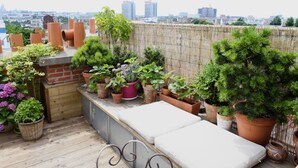 A rooftop garden with various potted plants and a seating area. - Le Rooftop Aux Puces - Terrasse rooftop (Saint Ouen)