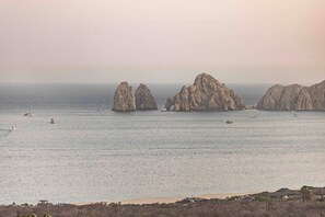 Un paysage côtier caractérisé par des formations rocheuses et une mer calme.