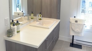 Un bagno moderno con uno specchio grande, due lavandini e un portascopevoli.