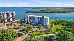 Ein modernes Hotel mit mehreren Etagen, einem Parkplatz und Blick auf das Meer und die Inseln.