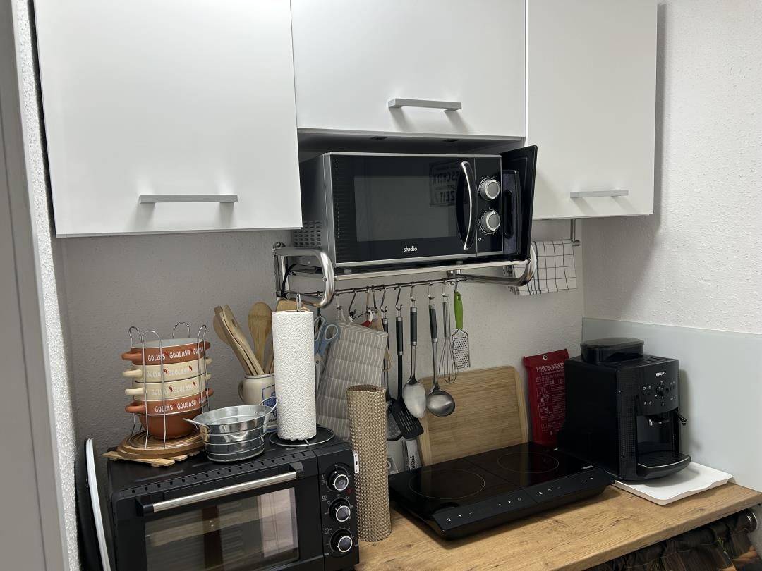 Eine Küche mit Mikrowelle, Kaffeemaschine und verschiedenen Küchenutensilien.