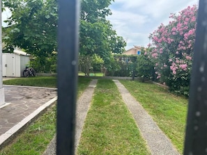 A garden with a paved path, a bicycle, and a shed. - BERTO'S HOUSE2 (TREPORTI)