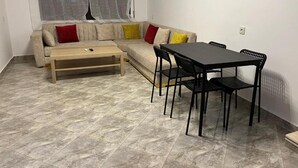 Un salon comprenant un canapé, une table basse et une table à manger avec des chaises.