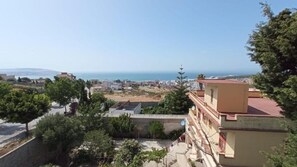 A coastal cityscape with buildings, trees, and a clear view of the sea. - capuchino sanya (Tanger)