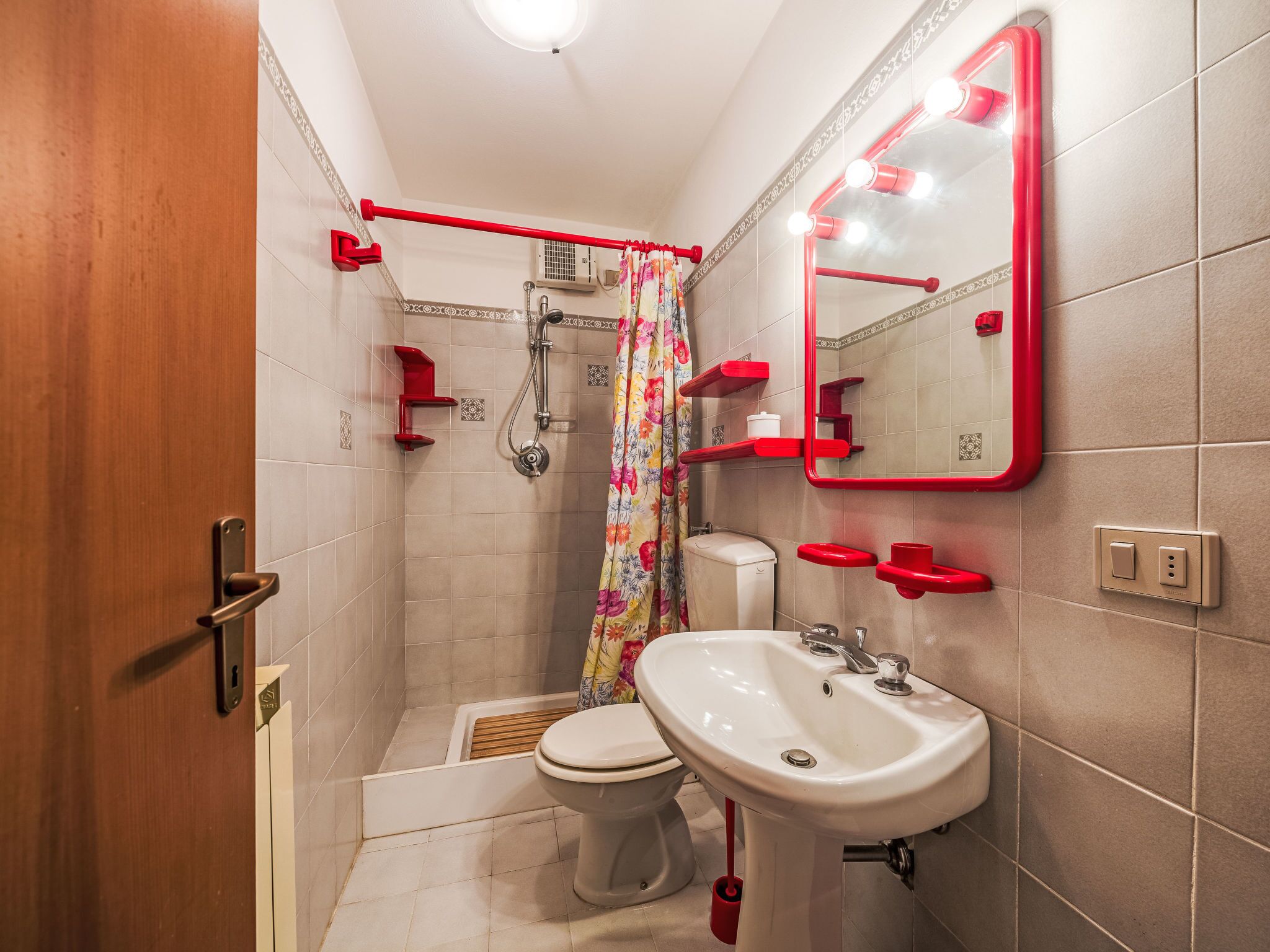 Une salle de bain équipée d’une douche, de toilettes, d’un lavabo et d’un miroir avec éclairage.