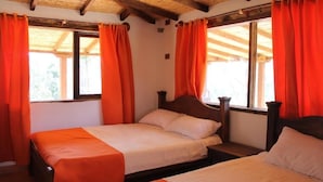 A room with two beds, wooden headboards, and orange curtains. - POSADA EL ARTESANO DE RAQUIRA (Ráquira)
