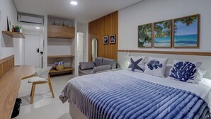 Une chambre moderne avec un lit, un bureau et une chaise. On y trouve deux tableaux encadrés au mur, un miroir et un panneau décoratif en bois.