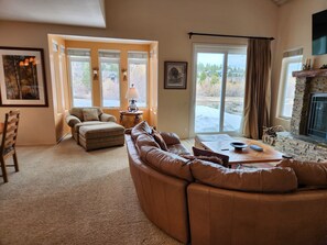 A living room with a sectional sofa, a round coffee table, and a fireplace. - Snowcreek Resort Vacation Rental 511 (Mammoth Lakes)