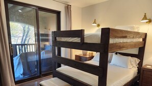 A bunk bed with a wooden headboard, a bench, and a bedside table with a lamp. - Snowcreek Resort Vacation Rental 1595 (Mammoth Lakes)