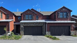 A three-story house with a stone foundation, a garage, and a driveway. - Snowcreek Resort Vacation Rental 1595 (Mammoth Lakes)