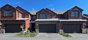 A three-story house with a stone foundation, a garage, and a driveway. - Snowcreek Resort Vacation Rental 1595 (Mammoth Lakes)