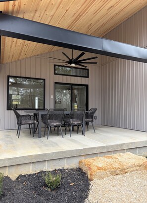 An outdoor patio with a table and chairs, a ceiling fan, and a view of the surrounding area. - The Lodge at Mammoth Cave - Private Nature Retreat (Cave City)