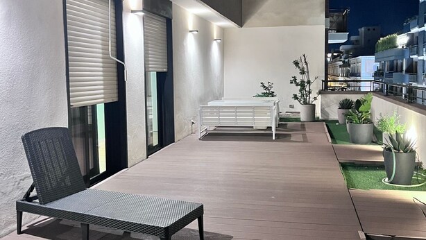 An outdoor patio area with a lounge chair, a small table, and potted plants. - Best Stay-Apartments in Andrea da Bari 5 (Bari)