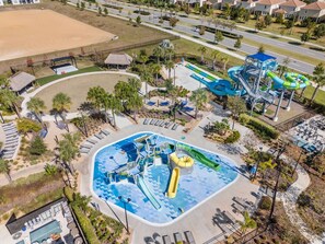 An aerial view of a water park with a central pool, slides, and a water slide structure. - Spacious 4 Bed, 3 Bath Home Min To Disney w/ POOL (Kissimmee)