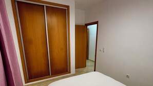 Una camera da letto con un letto grande, un armadio in legno e uno specchio.