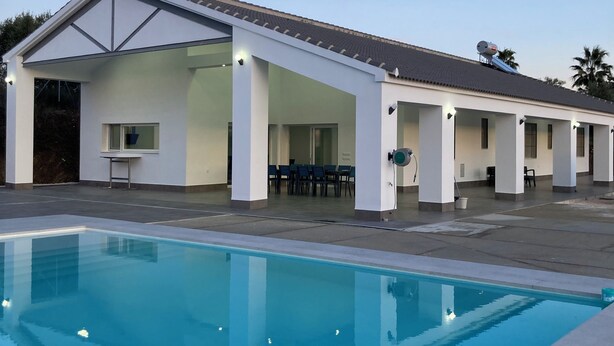 Un edificio moderno con un espacio exterior cubierto y una piscina.
