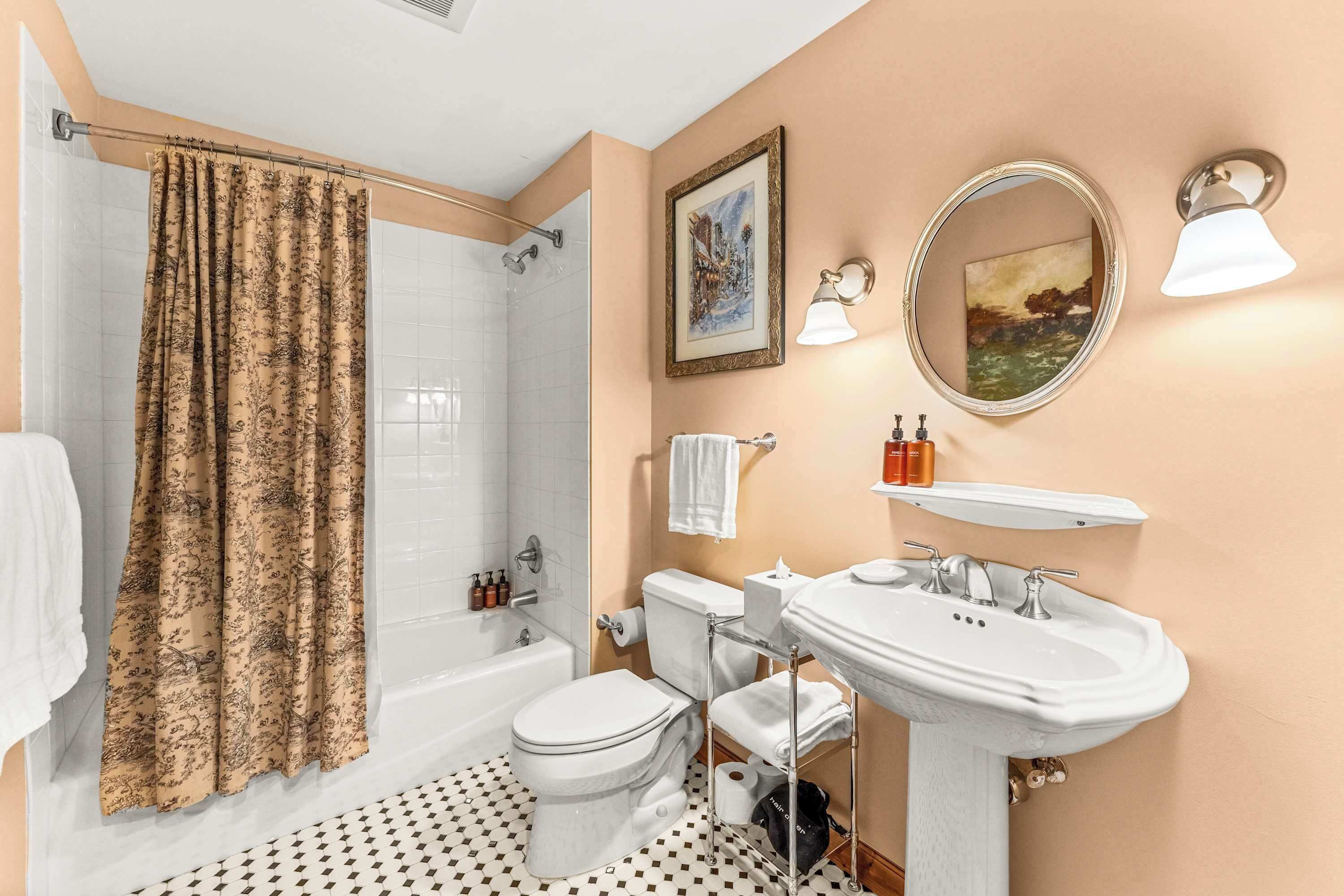 Une salle de bain équipée d’une baignoire, de toilettes, d’un lavabo et d’un rideau de douche.