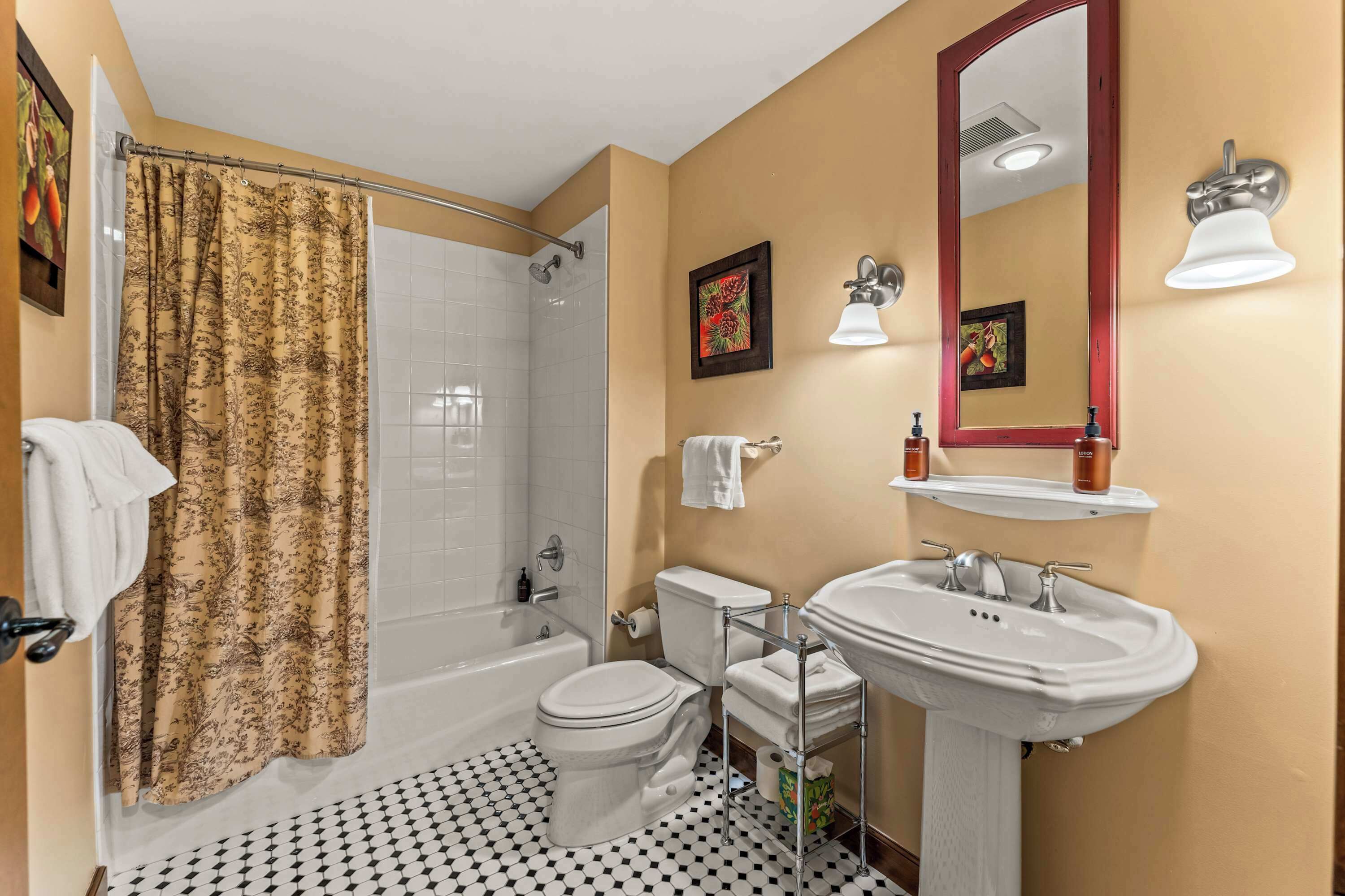 Een badkamer met een bad, toilet, wastafel en douchegordijn.