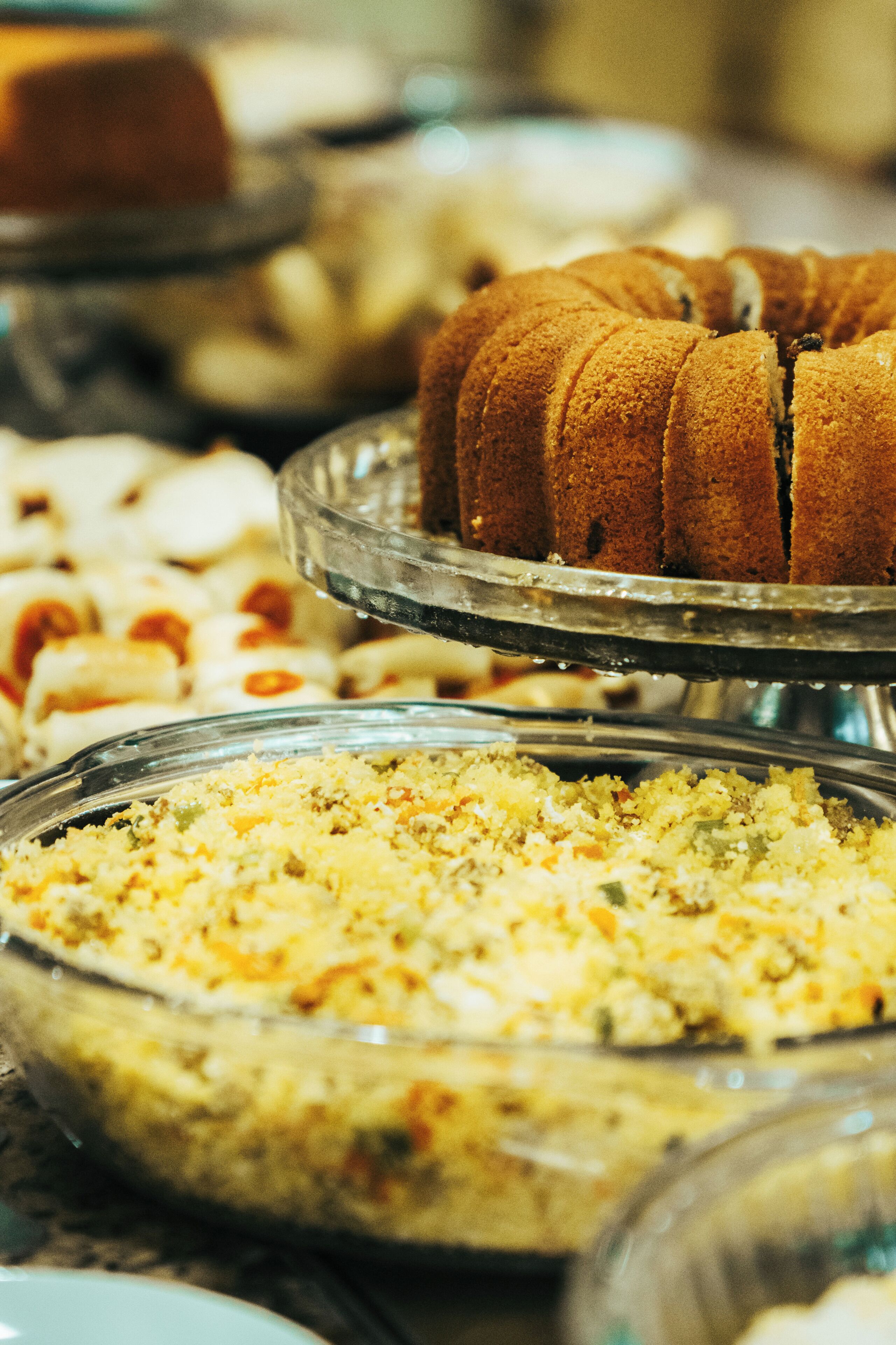A variety of food items on display, including a bundt cake and a casserole dish.