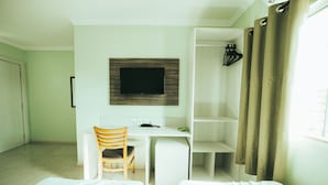 A hotel room with a desk, chair, TV, and two beds. - Hotel Durma Bem (Castanhal)