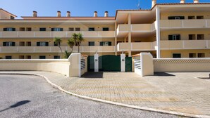 Ein mehrstöckiges Hotel mit zentralem Eingang, Balkonen und einer gepflasterten Auffahrt.