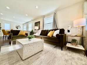 A modern living room with a sofa, coffee table, and lamp. - Cute & Cozy House in Quiet Blue Ash Neighborhood (Blue Ash)