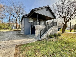 A two-story house with a stone staircase and a garage.