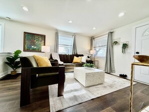A modern living room with a sofa, coffee table, and a potted plant.