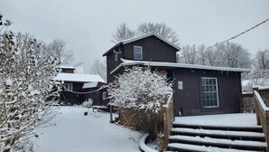 A wooden house with a snow-covered roof and steps leading to the entrance. - Newton Lake (Carbondale)