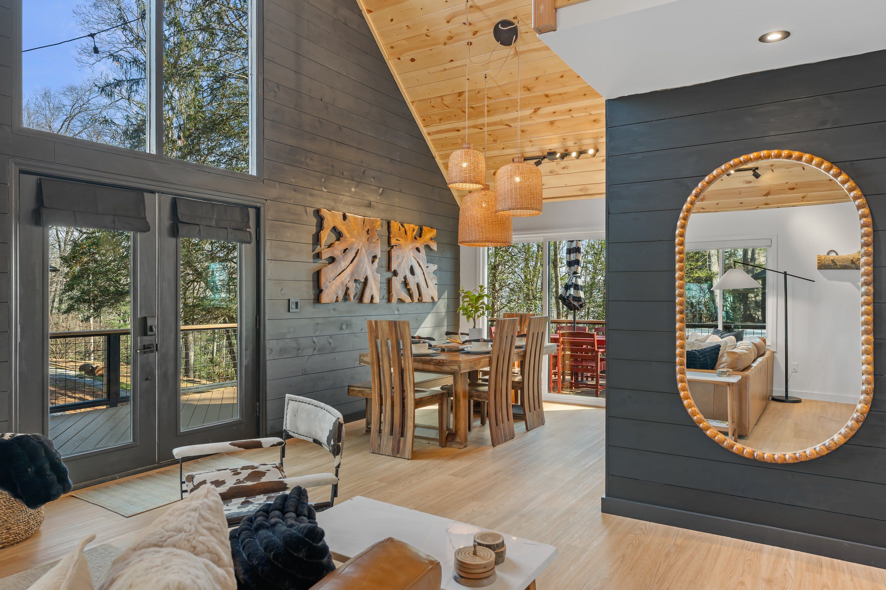 Ein modernes Interieur mit Essbereich, einem großen Spiegel und Blick ins Freie.