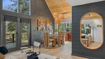 Un intérieur moderne comprenant un coin repas, un grand miroir et une vue sur l’extérieur.