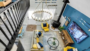 Una sala de estar moderna con un sofá, sillones amarillos, una mesa de centro y una chimenea.