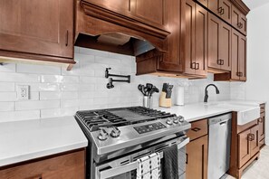 A kitchen with wooden cabinets, a stainless steel stove, a dishwasher, and a white tiled backsplash. - Highlands Retreat w/Hot Tub, Parking & Large Fenced Back Yard (Louisville)