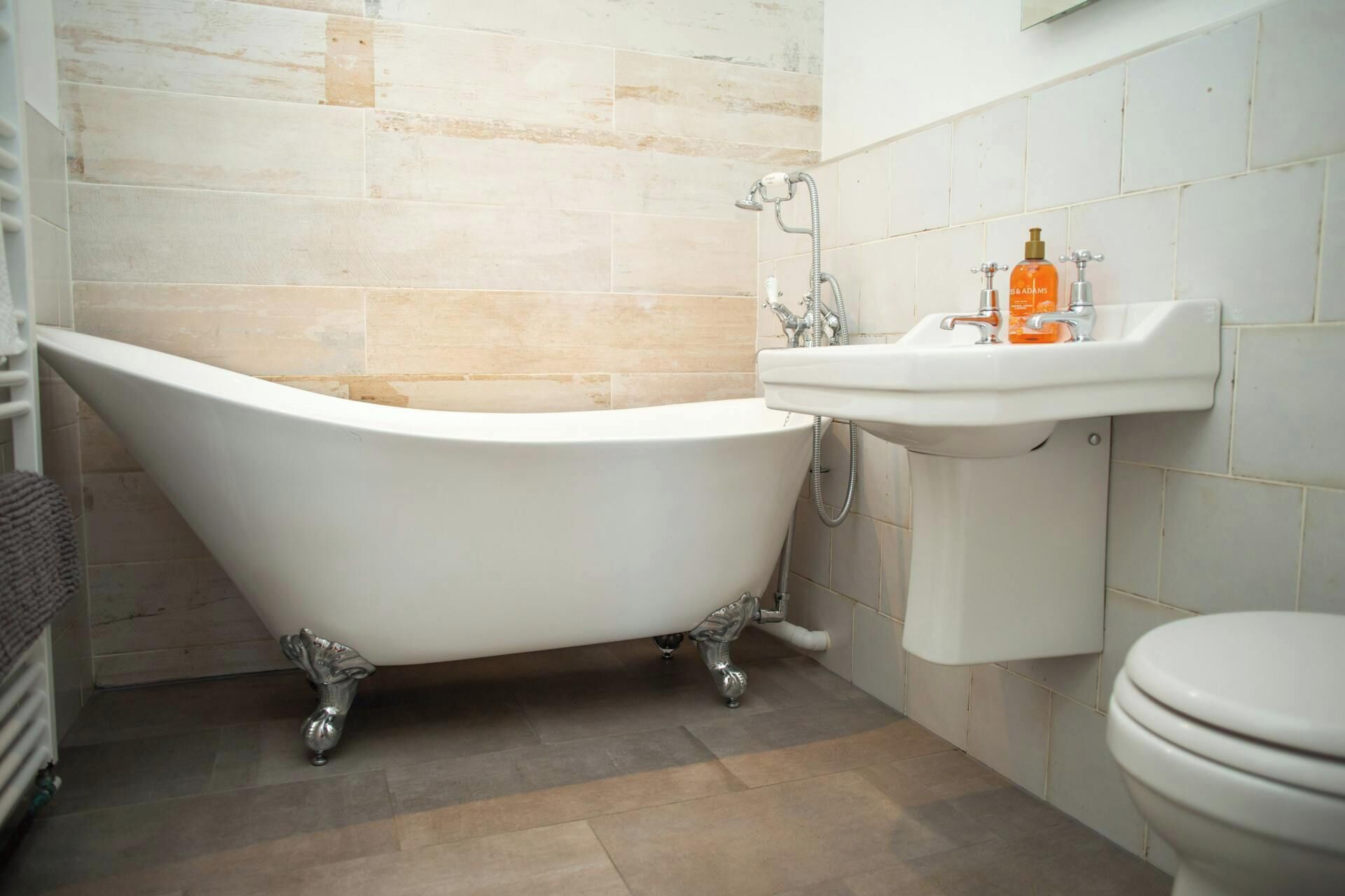 A bathroom with a freestanding bathtub, a sink, and a toilet.
