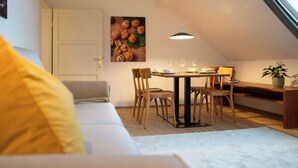 Un loft acollidor amb zona de menjador, un sofà i una finestra gran.