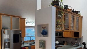 A modern kitchen with a stainless steel refrigerator, wooden cabinets, and a bar area with stools. - 3bed 3bath sleeps 8 @ Hidden Valley is a ski in-out oasis steps for the action.  (Somerset)
