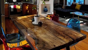 A modern kitchen with wooden cabinets, a stainless steel refrigerator, and a dining area with a wooden table and chairs. - 3bed 3bath sleeps 8 @ Hidden Valley is a ski in-out oasis steps for the action.  (Somerset)