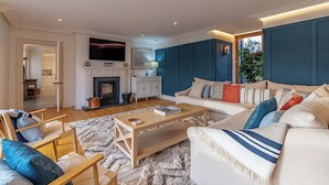 A living room with a fireplace, sofa, coffee table, and a television mounted on the wall.