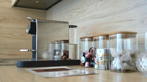 Una cocina con cafetera, frascos de especias y encimera de madera.