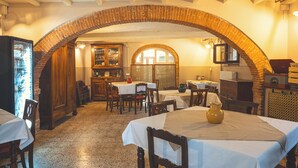 Un espace repas avec des tables, des chaises et une arche en briques.