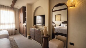 A modern hotel room with a large bed, a TV, a wooden cabinet, and a mirror. - Pyramids Pavilion Boutique Hotel (Giza)