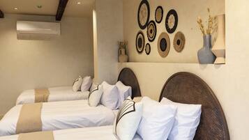 Camera d'albergo con due letti, condizionatore d'aria a parete e decorazioni murali.