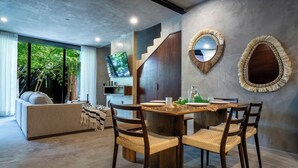 A modern living room with a dining area, large windows, and a staircase. - Villa Cruz, Private Pool, Near Beach, Concierge (Tulum)