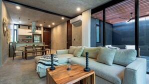 A modern living room with a sofa, coffee table, and dining area. - Villa Cruz, Private Pool, Near Beach, Concierge (Tulum)