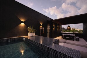 A rooftop pool area with a tiled floor, a seating area with a table and chairs, and a view of the cityscape. - Duo Luxury Villas, 5 Pools, 2 Rooftops, 24 Guests (Tulum)