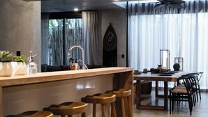 Et moderne køkken med bar, træbænk og spisebord med stole.