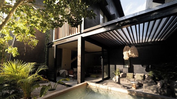 Et moderne poolområde udendørs med et minimalistisk design, omgivet af plantekasser og en træterrasse.