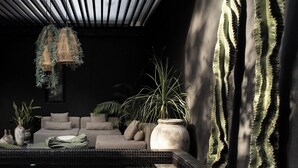 A modern indoor pool area with a sofa, potted plants, and hanging lights. - Design Luxury Villa, 3 Pools, Rooftop, Near Beach (Tulum)