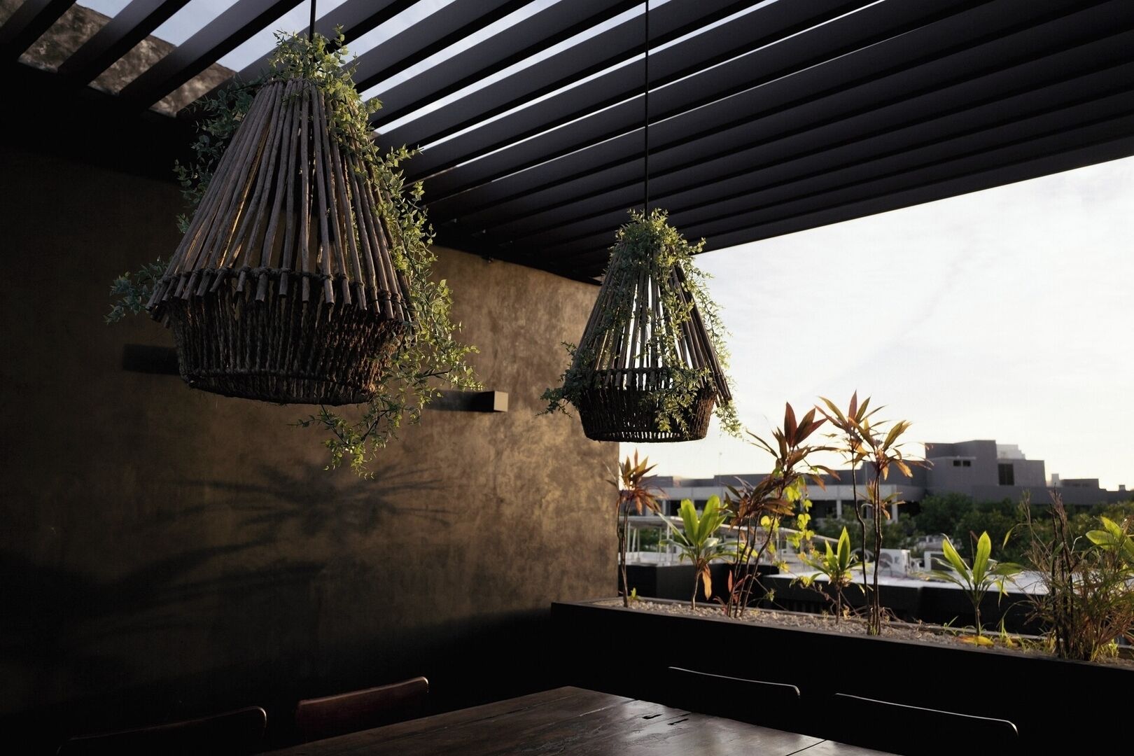 Un interior moderno con plantas colgantes y vistas de edificios.
