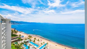 A beachfront hotel with a pool, beach, and ocean view. - Stylish Beachfront 2BR | Balcony Sunsets & Pools (Puerto Vallarta)